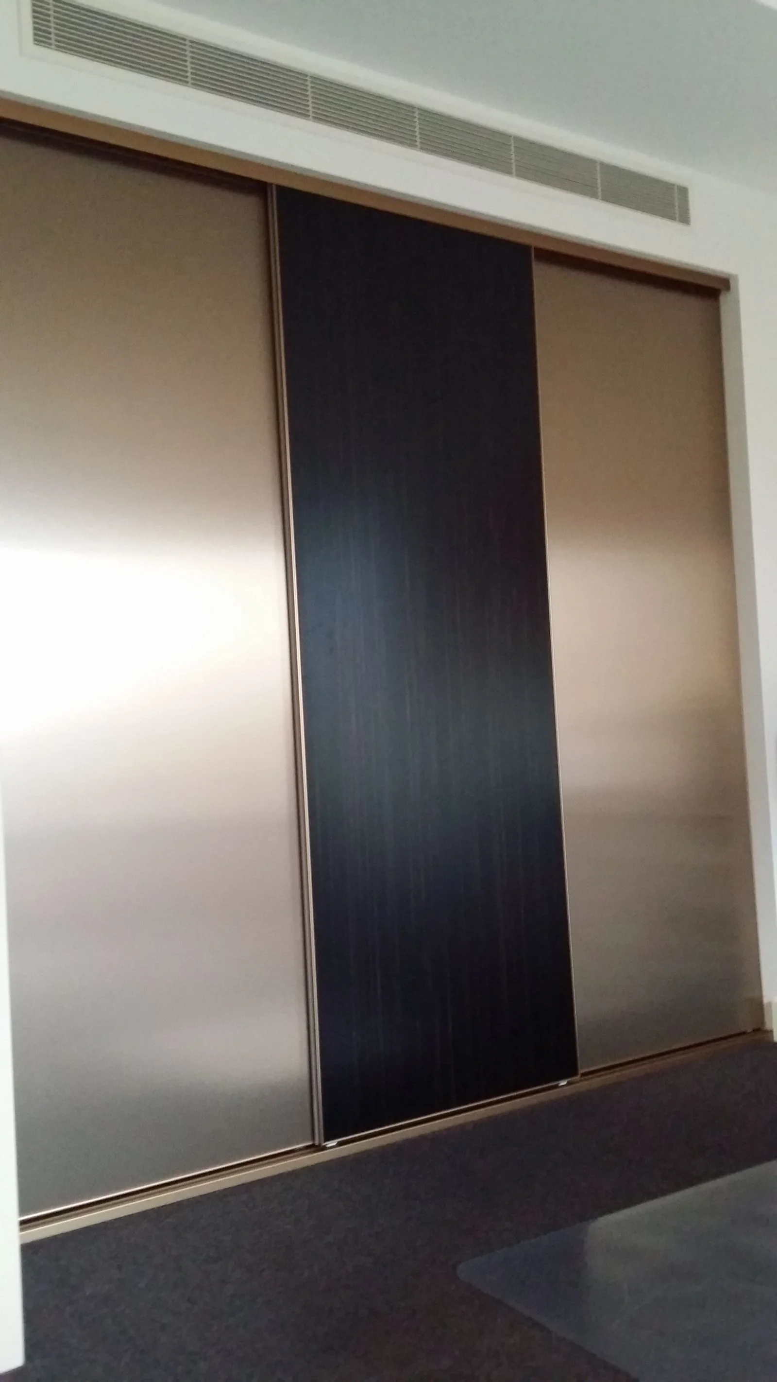 Built-in wardrobe with white sliding doors in a bright bedroom