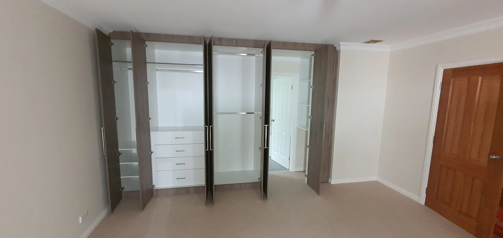 Built-in wardrobe with white hinged doors and floor-to-ceiling storage