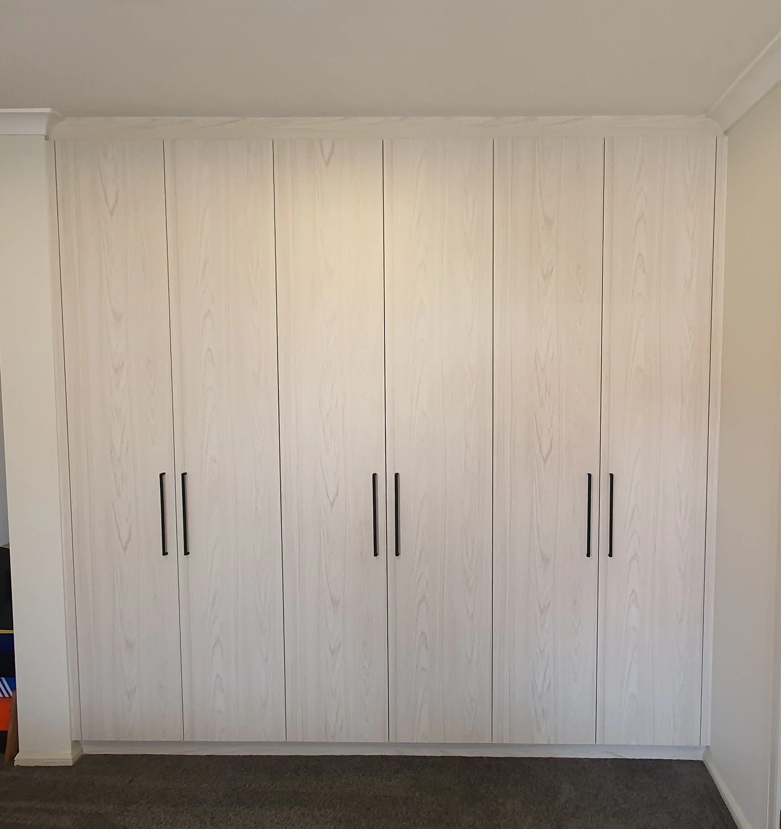 Compact built-in wardrobe fitted by Brodco in a small bedroom