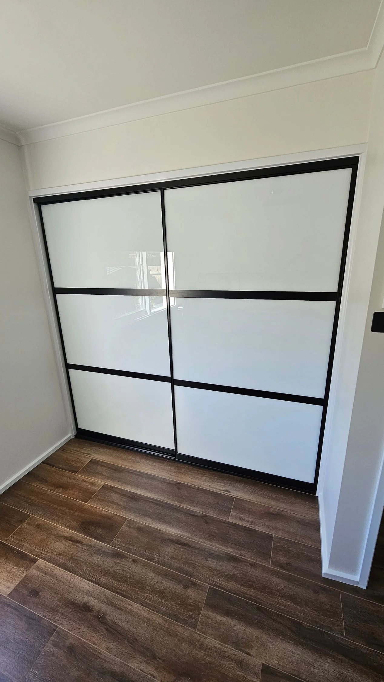 Built-in wardrobe with sliding doors fitted by Brodco in a rural home