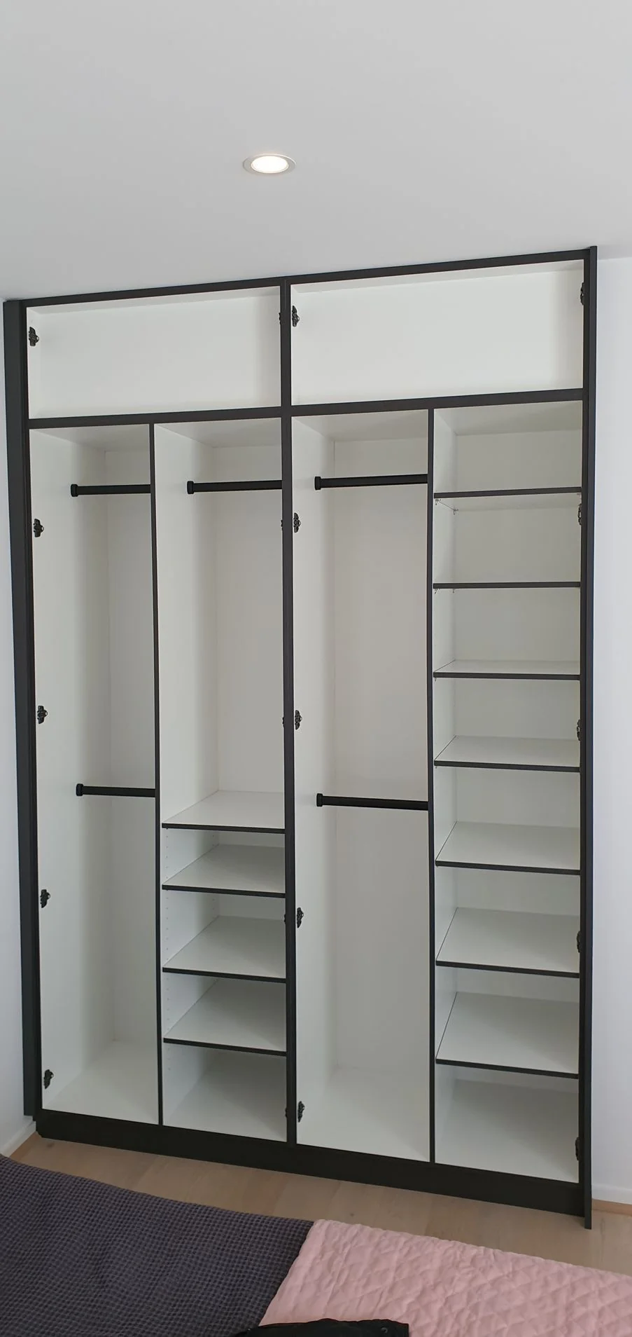 Built-in wardrobe with timber-panel hinged doors and brass handles