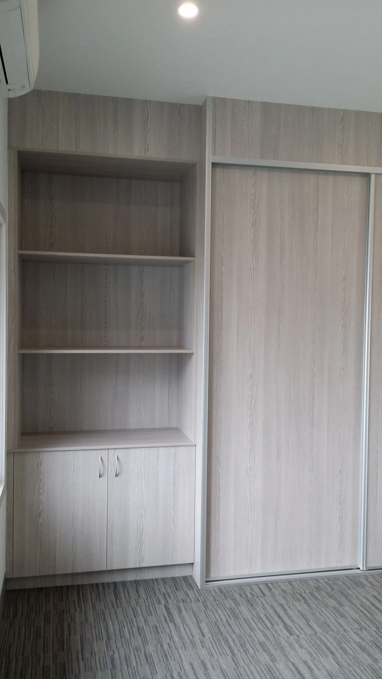 Built-in wardrobe with white sliding doors and internal drawers