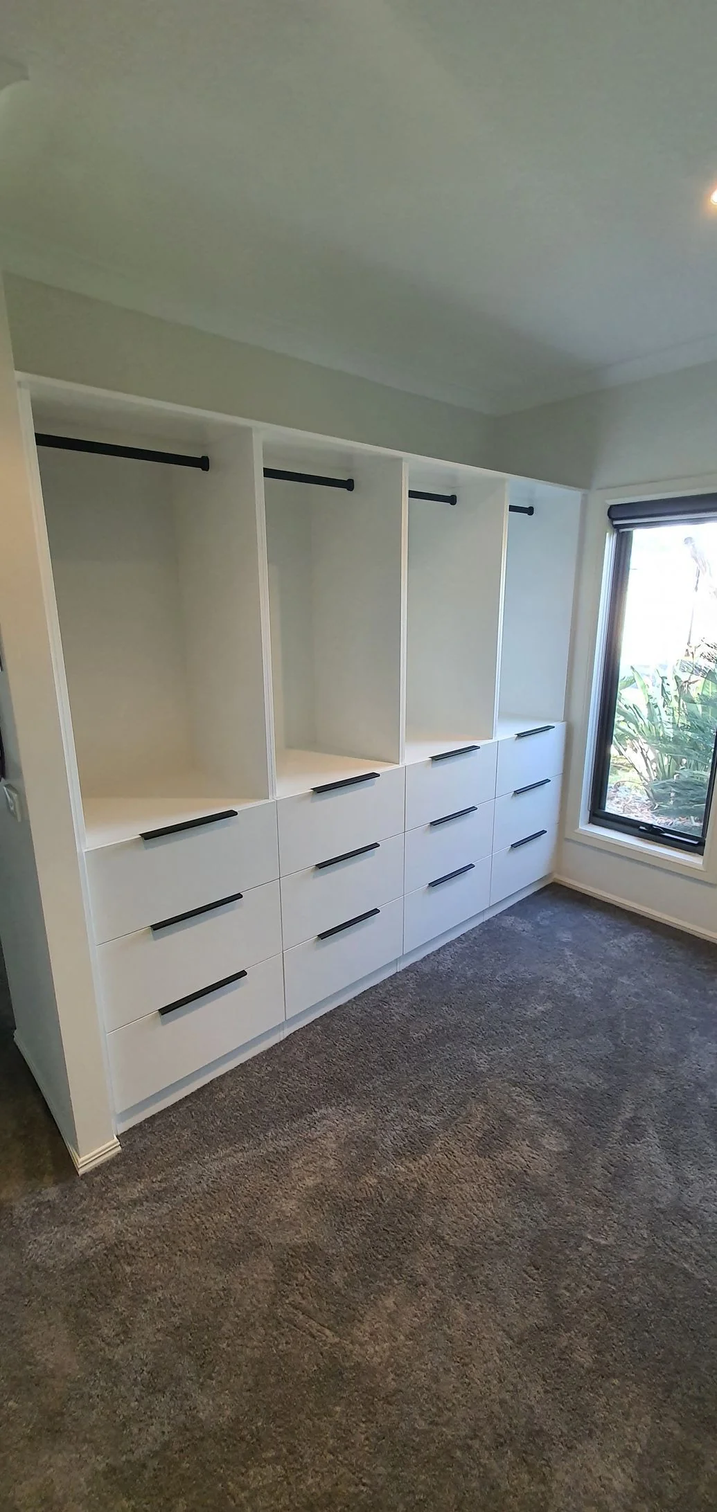 Built-in wardrobe with white sliding doors and floor-to-ceiling storage