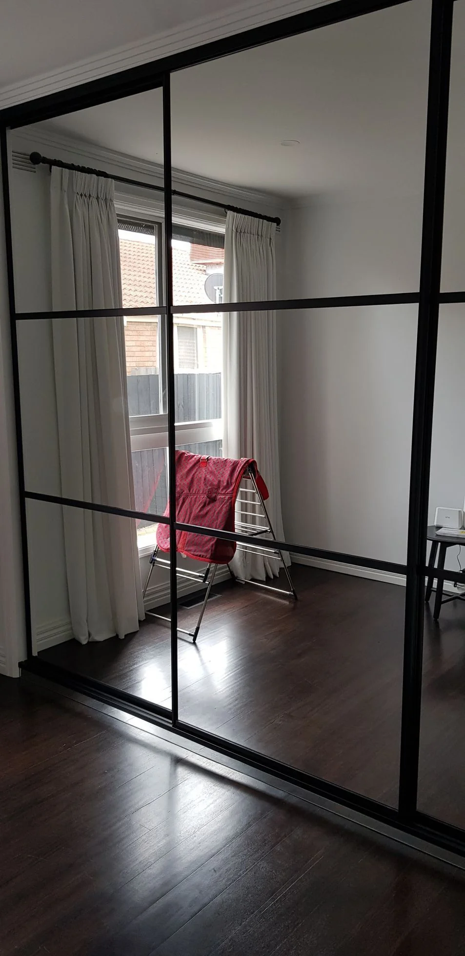 Timber-finish sliding-door built-in wardrobe in a bedroom corner