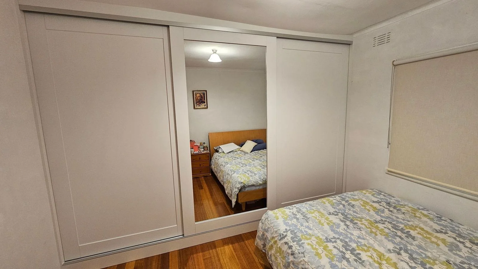 Built-in wardrobe with soft-close hinged doors in a bedroom
