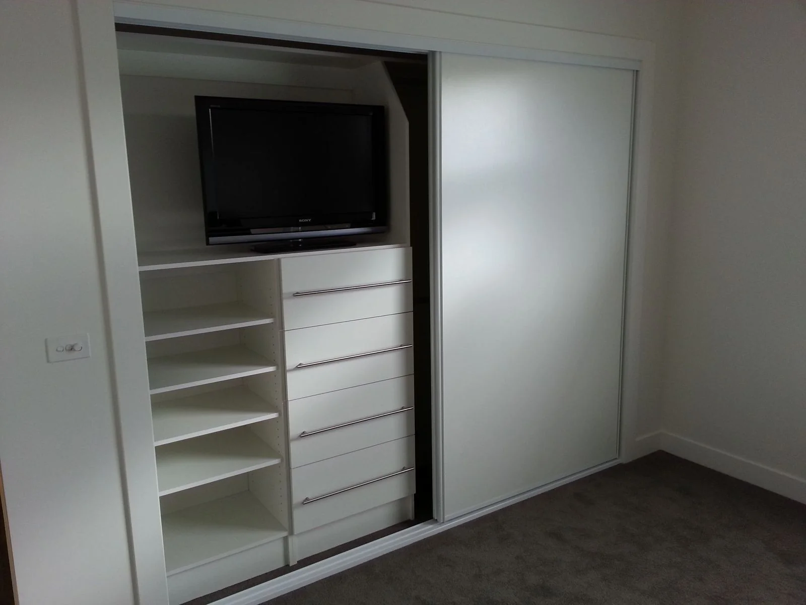 Built-in wardrobe with timber-look hinged doors and brushed handles