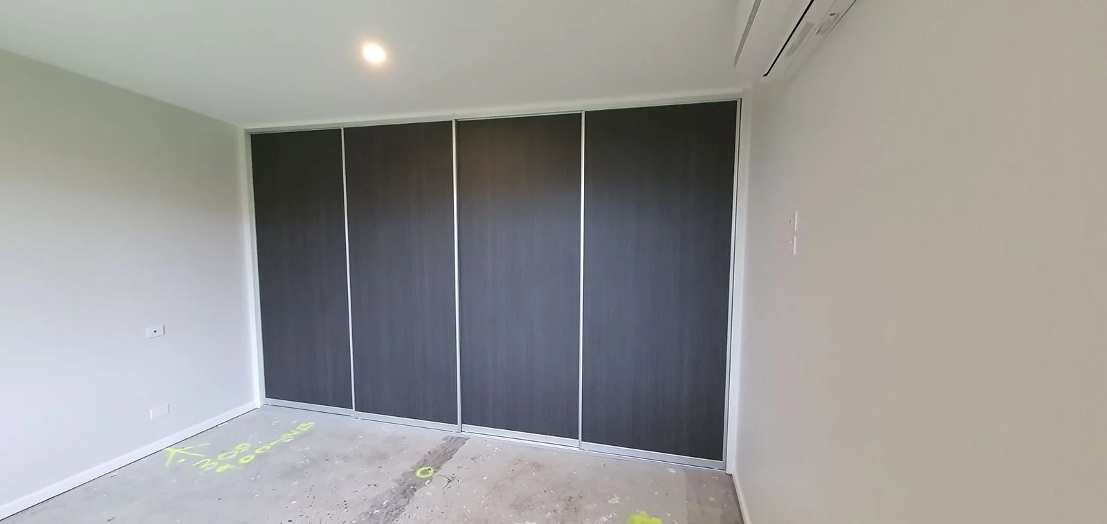 Built-in wardrobe with dark timber-look sliding doors