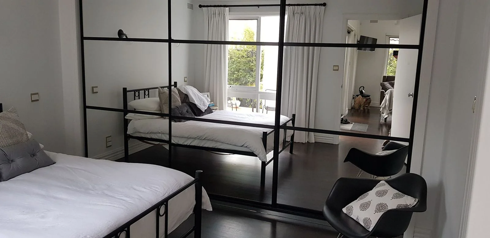 Built-in wardrobe with mirrored sliding doors in a bedroom