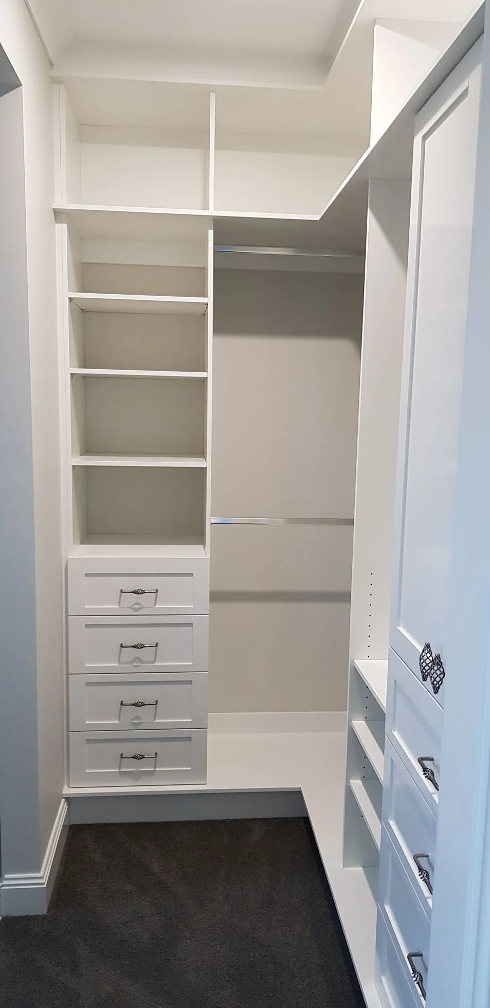 Built-in wardrobe with white hinged doors and brushed handles