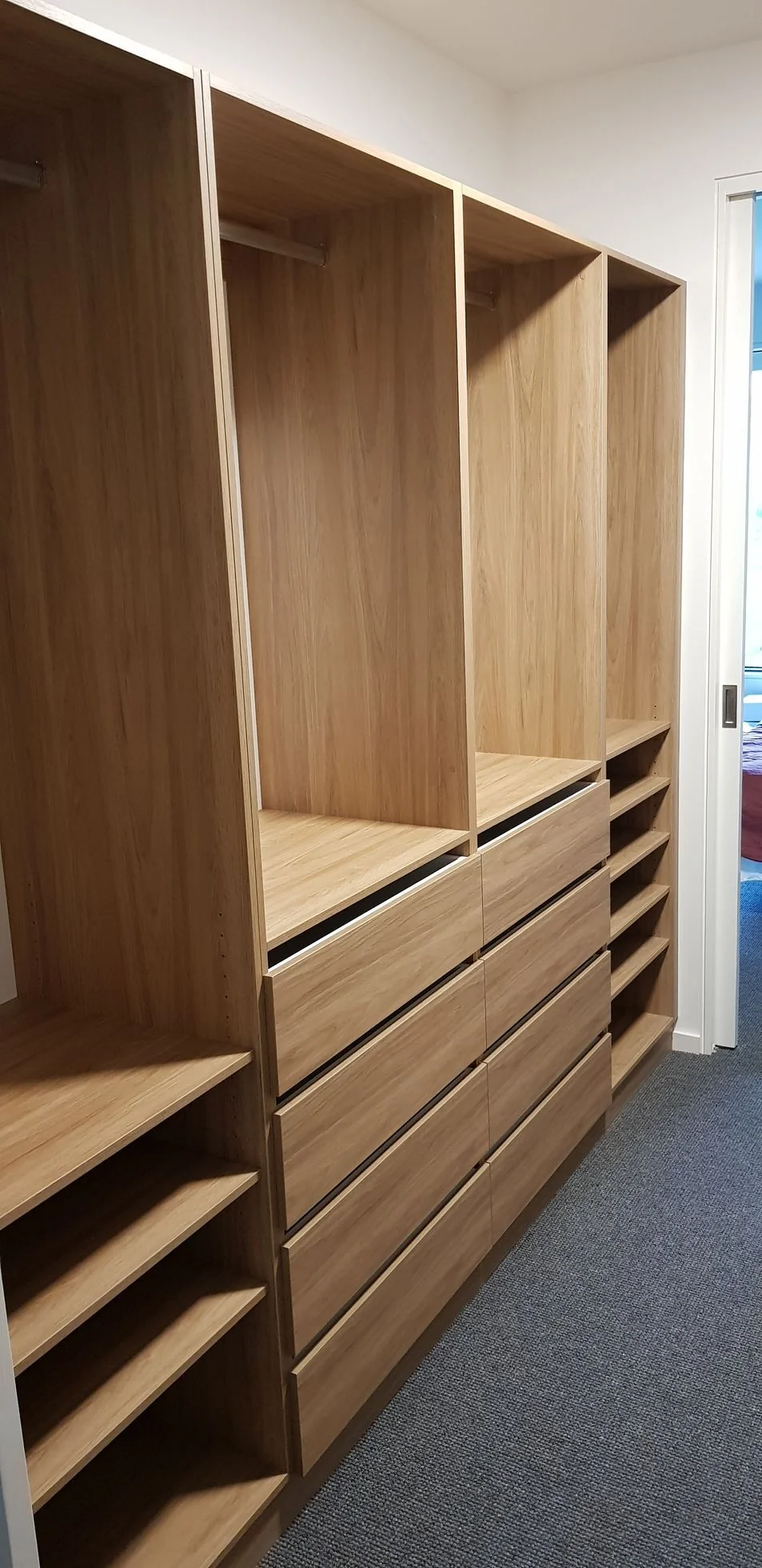 Built-in wardrobe with timber-panel hinged doors and brass handles